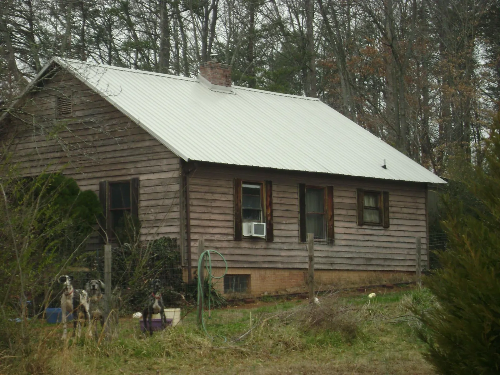 White metal roof on an old wood sided farmhouse, from a Metal Roof Installation job in Onsted